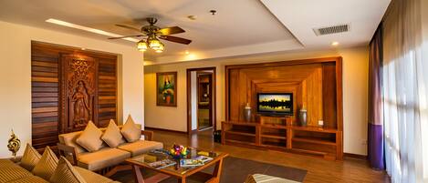 A spacious living room with a sofa set, a coffee table, and a television in the background.