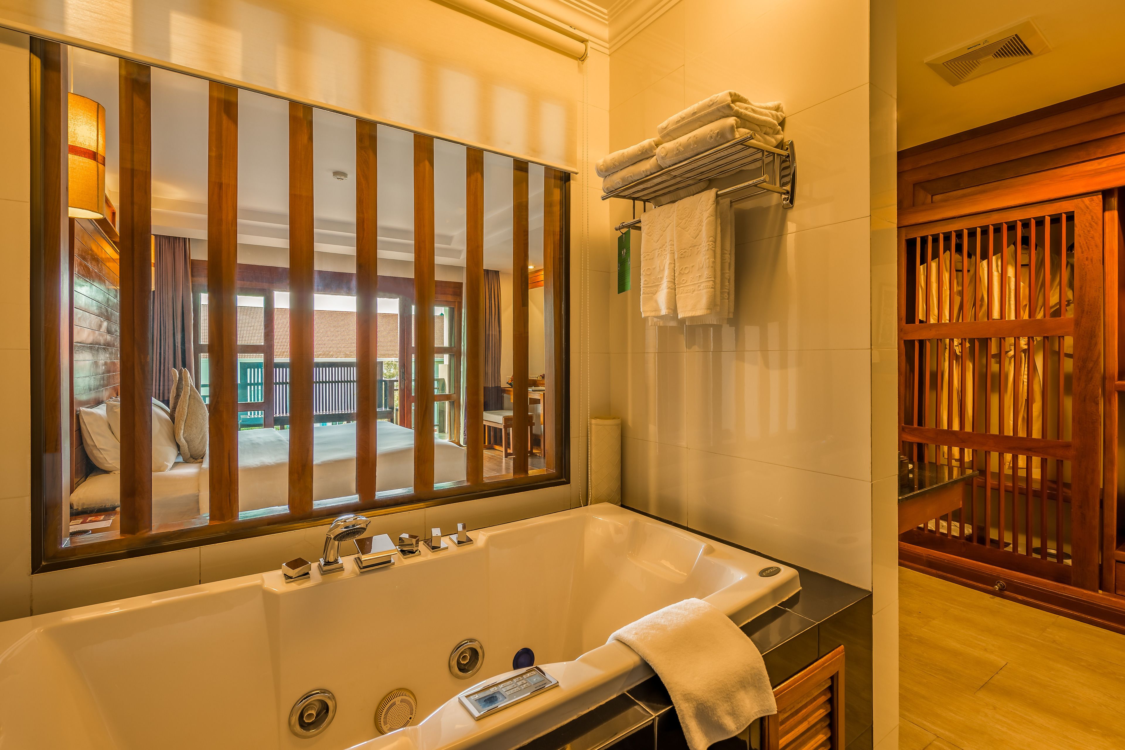 Un bagno moderno con una vasca da bagno ampia, uno specchio e vista sull'area esterna.