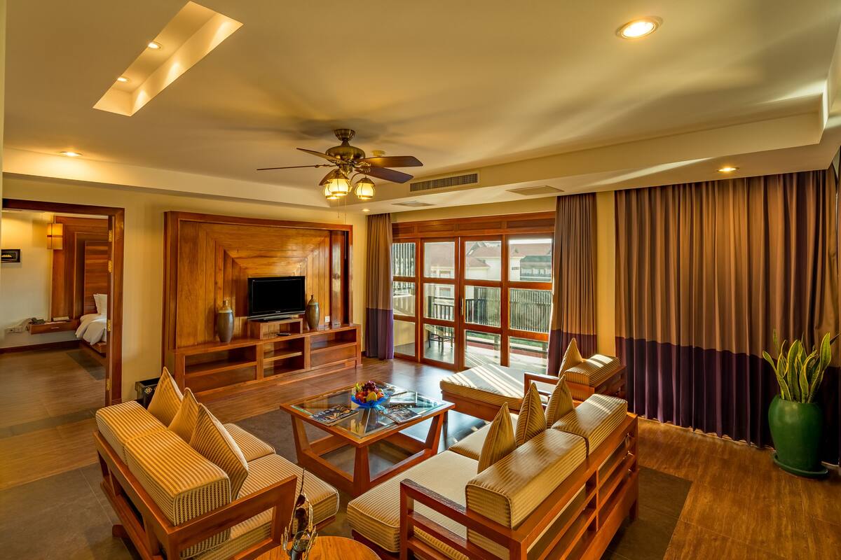 A spacious living room with a television, sofa, and a piano.