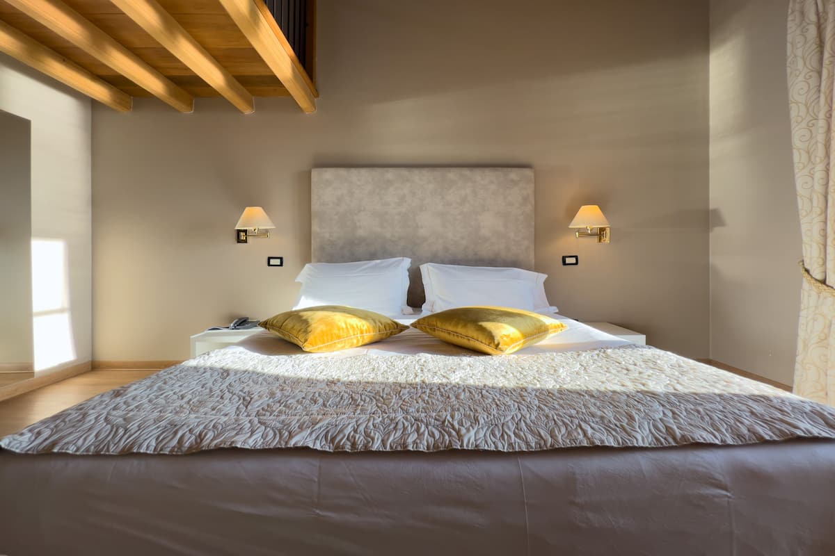 Une chambre à coucher avec un grand lit, deux lampes de chevet et une tête de lit.