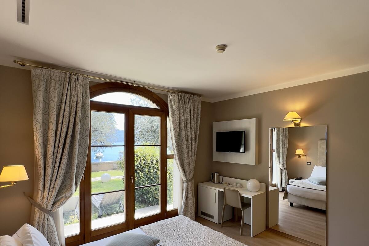 Une chambre d’hôtel avec un lit, un bureau et une télévision.