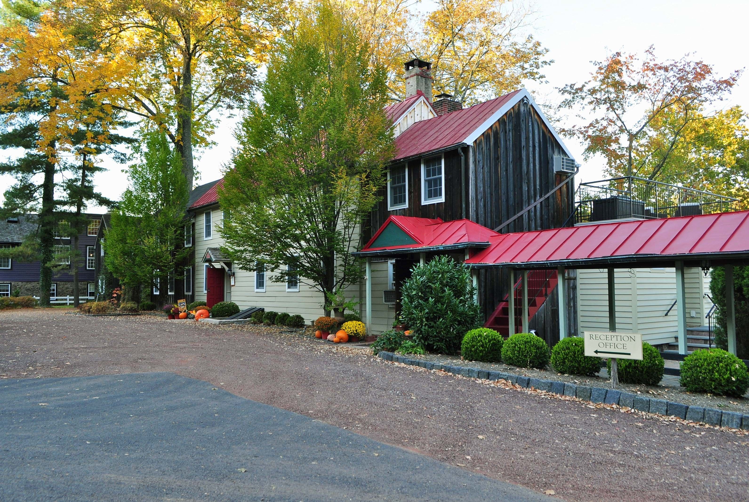 A rustic building with a red roof and a sign indicating a reception office.