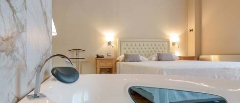 A hotel room with a marble wall, a bed with a tufted headboard, bedside lamps, and a white bathtub.