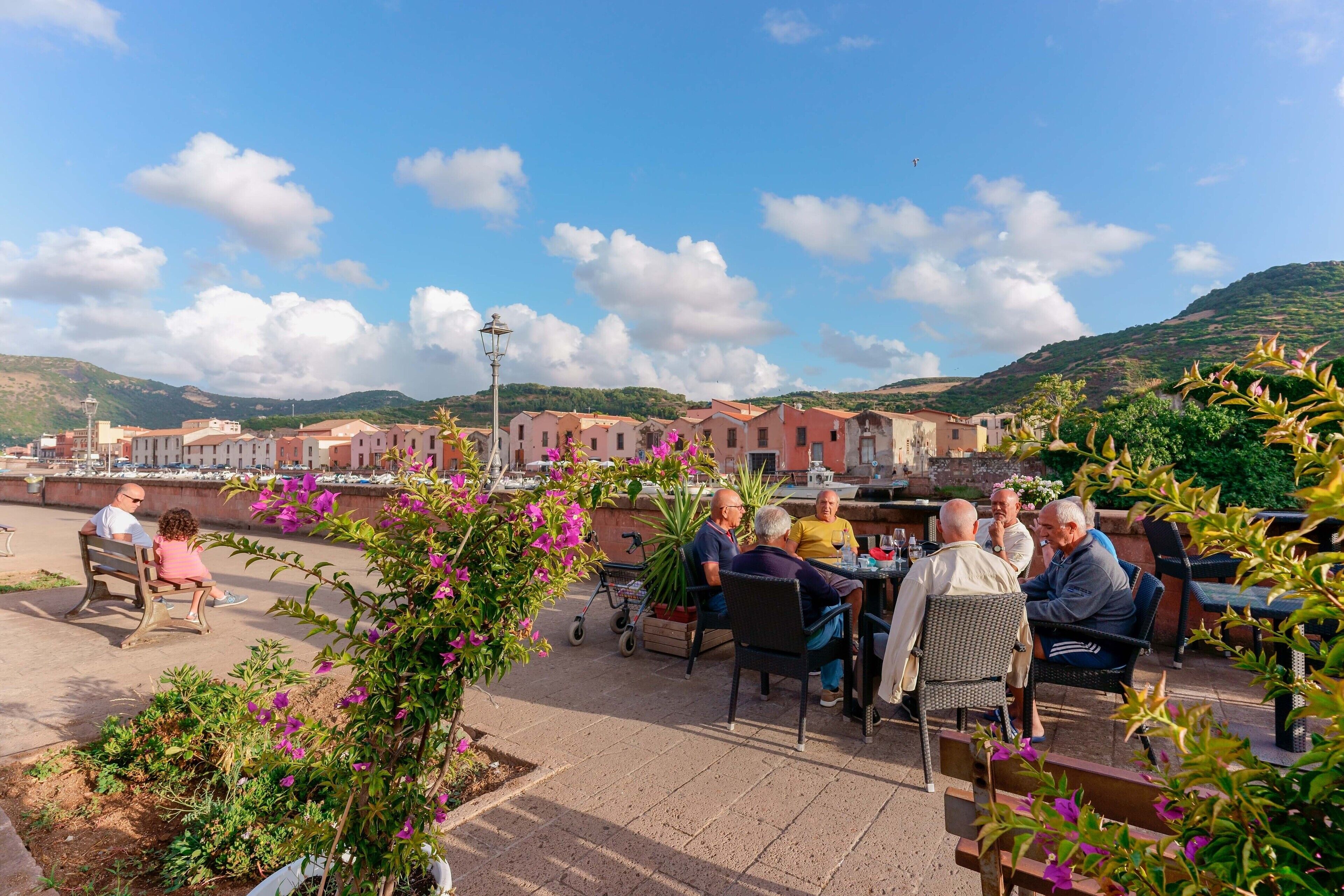 Una terraza con asientos al aire libre, vista a edificios y cielo despejado.
