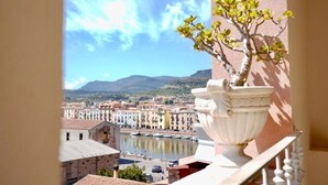 Un balcón con vista a un río, edificios y montañas.