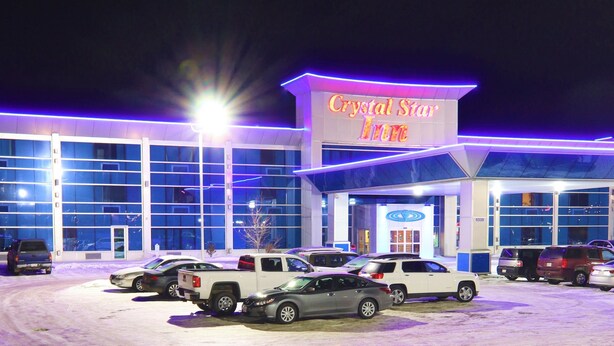 A hotel named Crystal Star Inn with a parking lot full of cars. - Crystal Star Inn Edmonton Airport (Leduc)