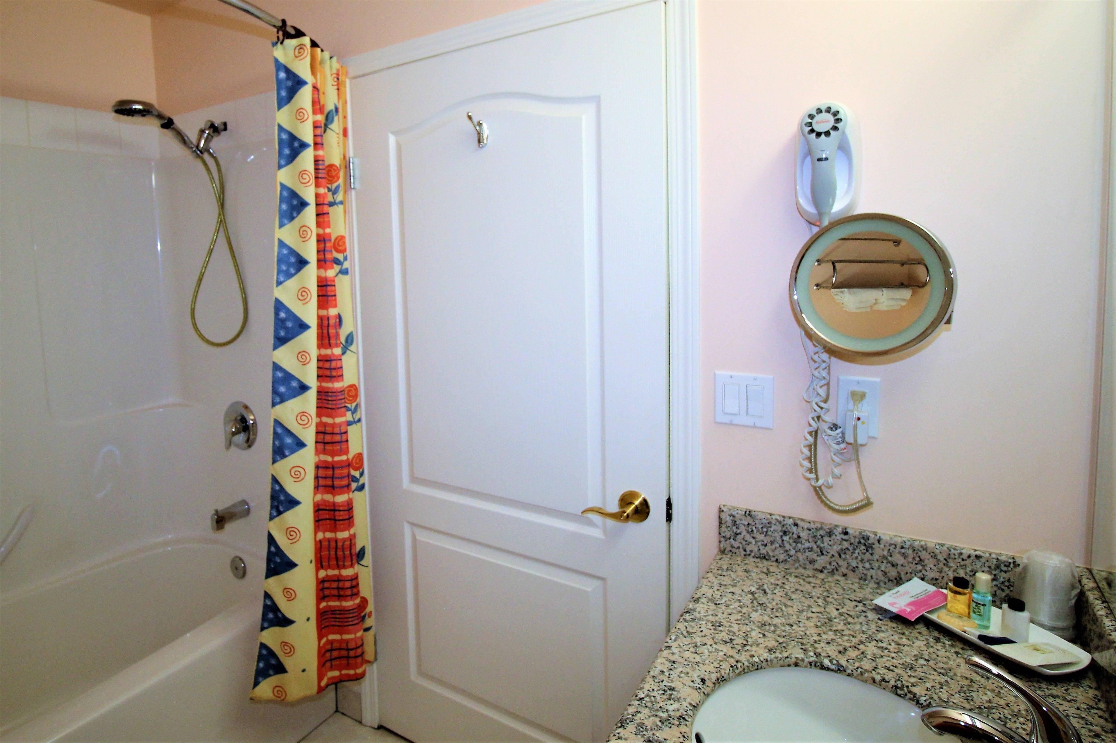 Un baño con ducha, inodoro, lavabo y espejo.