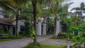 A courtyard with a paved walkway, palm trees, and a water feature. - Lotus Blanc Resort (Siem Reap)