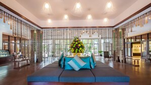 A spacious lobby with a central seating area, decorative panels, and hanging lights. - Lotus Blanc Resort (Siem Reap)