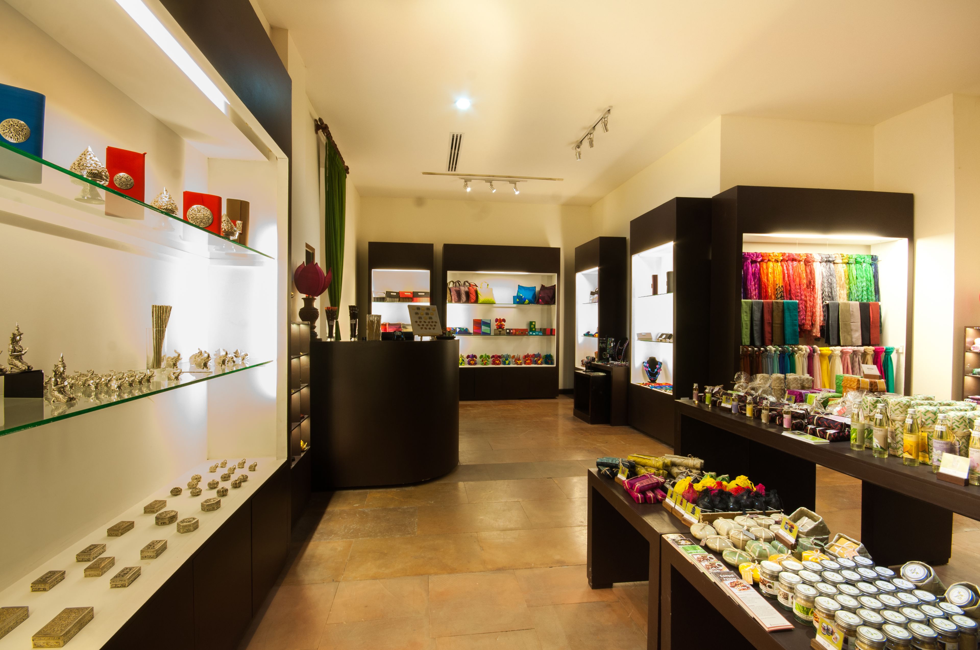 Une boutique élégante avec des étagères remplies de bijoux et de sacs, un espace central pour exposer les articles et un comptoir de caisse.