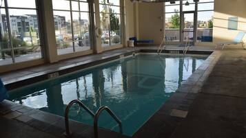 Una piscina techada, sillones reclinables de piscina