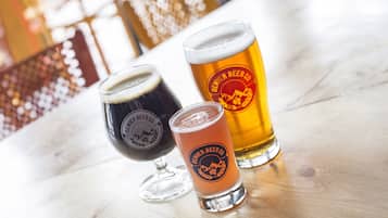 Three glasses of beer on a wooden surface.