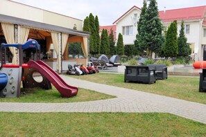 A playground with slides and a covered play area, outdoor seating, and a paved walkway. - Hotel SPA Faltom Gdynia Rumia (Rumia)