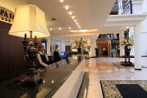 A hotel lobby with a reception desk, a large lamp, and a modern interior design. - Hotel SPA Faltom Gdynia Rumia (Rumia)
