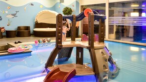Zona infantil con un tobogán y una piscina.