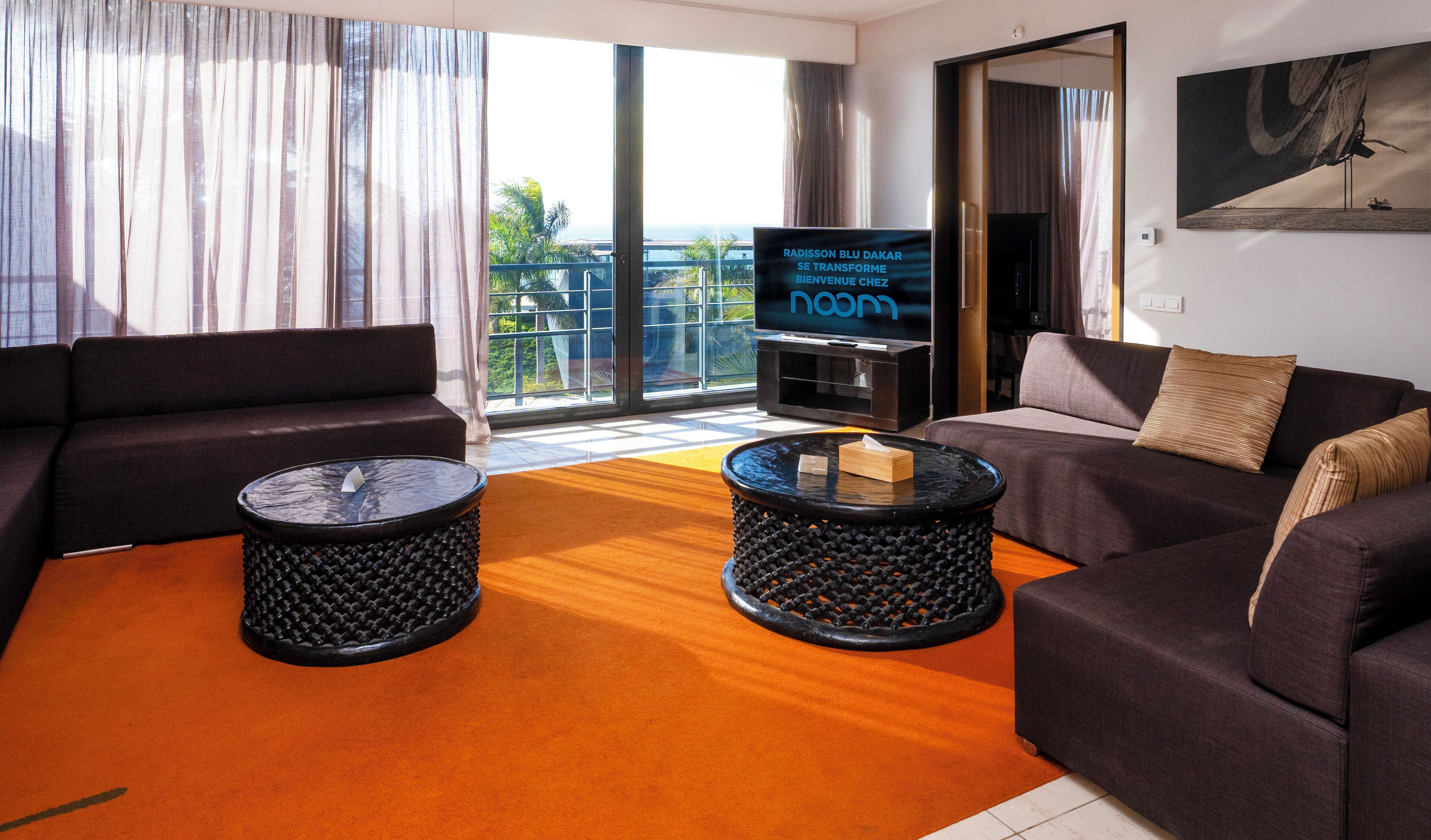 A modern living room with two sofas, a coffee table, and a flat-screen TV.