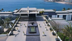Un hotel con jardín en la azotea, piscina y vistas al océano.