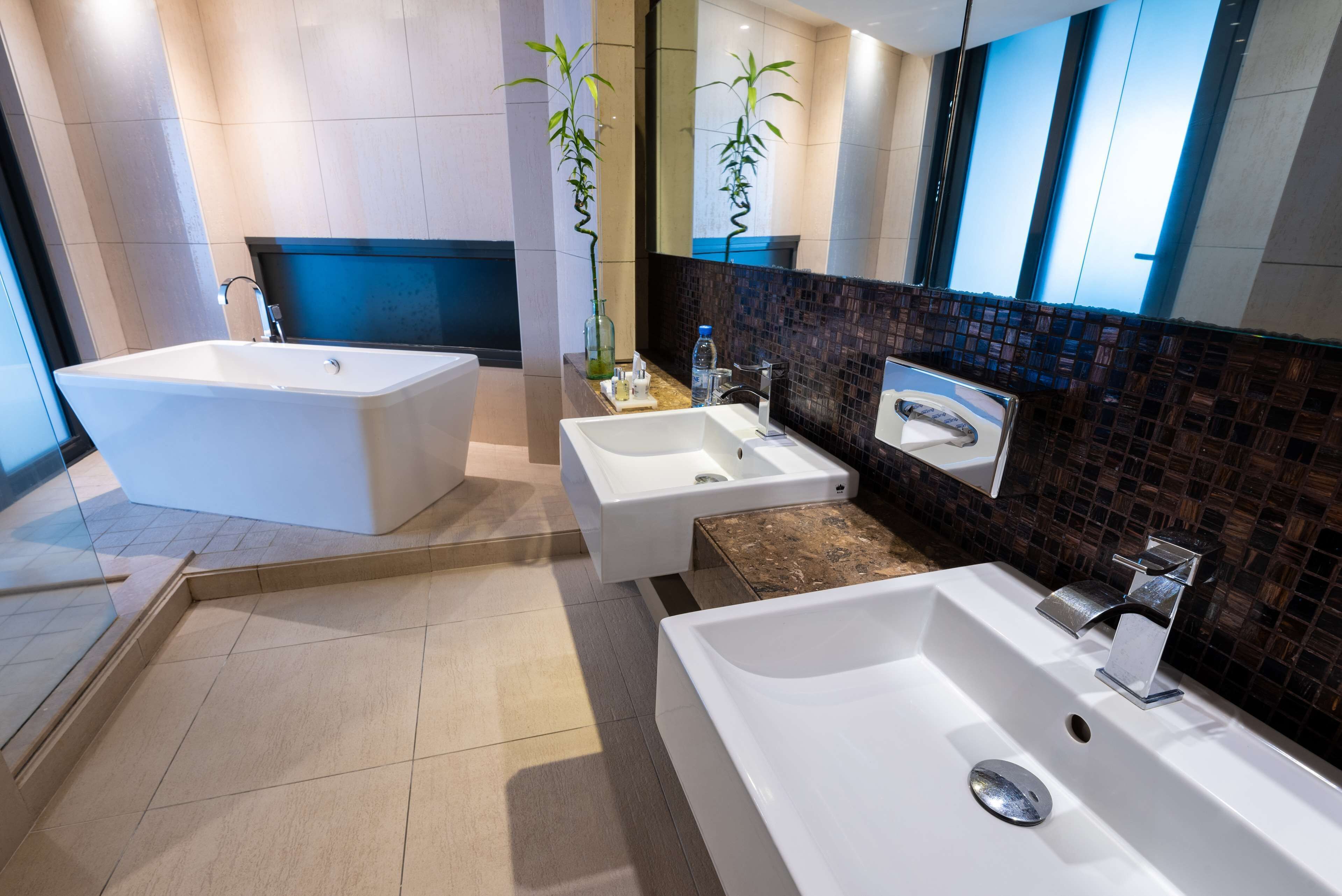 A modern bathroom with a freestanding bathtub, a sink, and a mirror.
