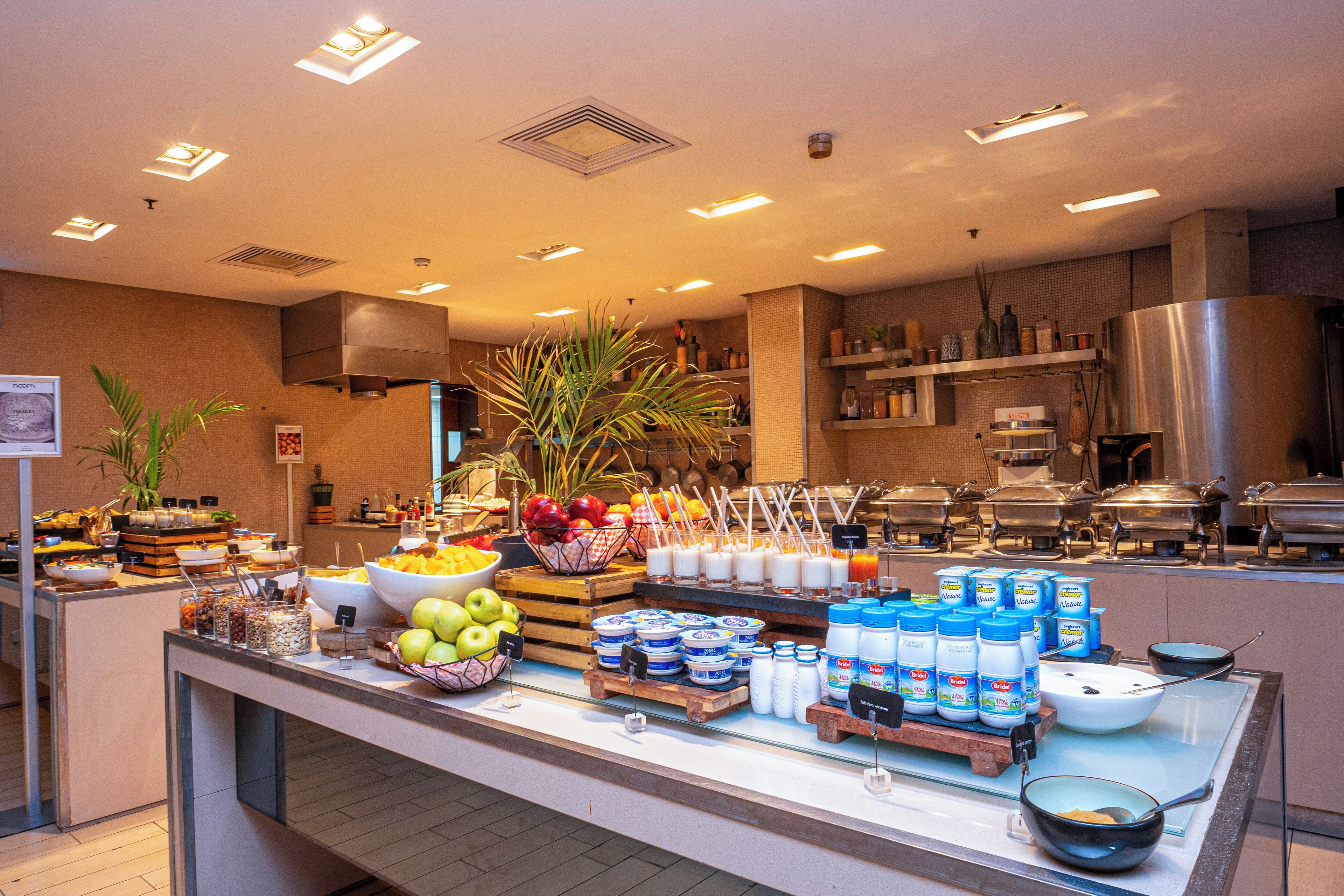 A buffet area with various food items, including fruits, dairy products, and condiments.