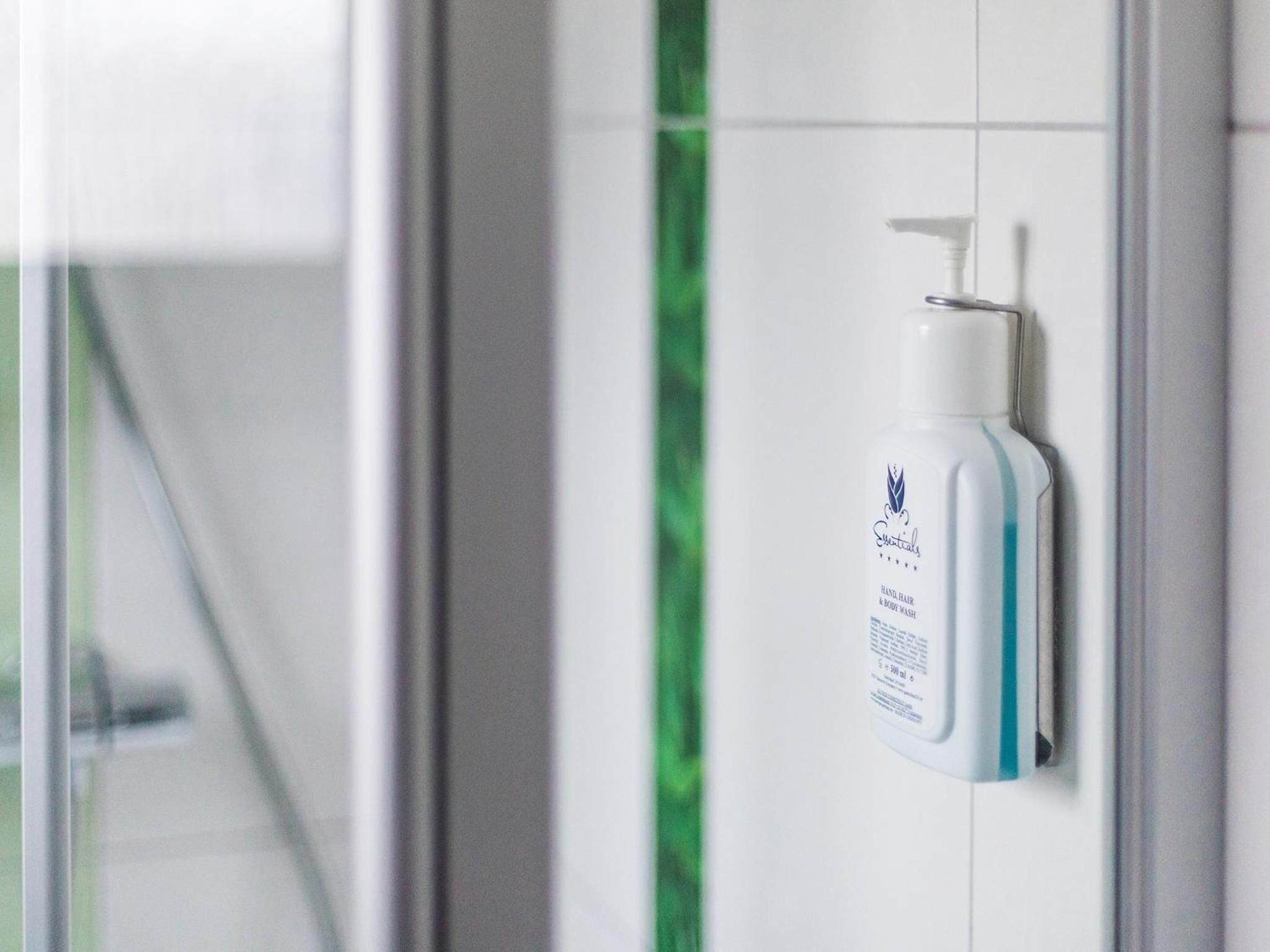 A bathroom with a hand sanitizer dispenser mounted on the wall.