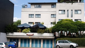A hotel with a sign reading "HOTEL & WIRTSAUS HANSEN" and a row of blue garage doors. - Hotel Hansen (Bergisch Gladbach)