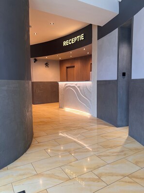 A reception area with a 'RECEPTION' sign, a wooden reception desk, and a tiled floor. - City Center Hotel Brasov (Brasov)