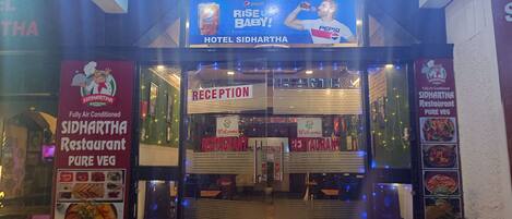 The entrance of Hotel Sidhartha with a reception area and signage for Sidhartha Restaurant.