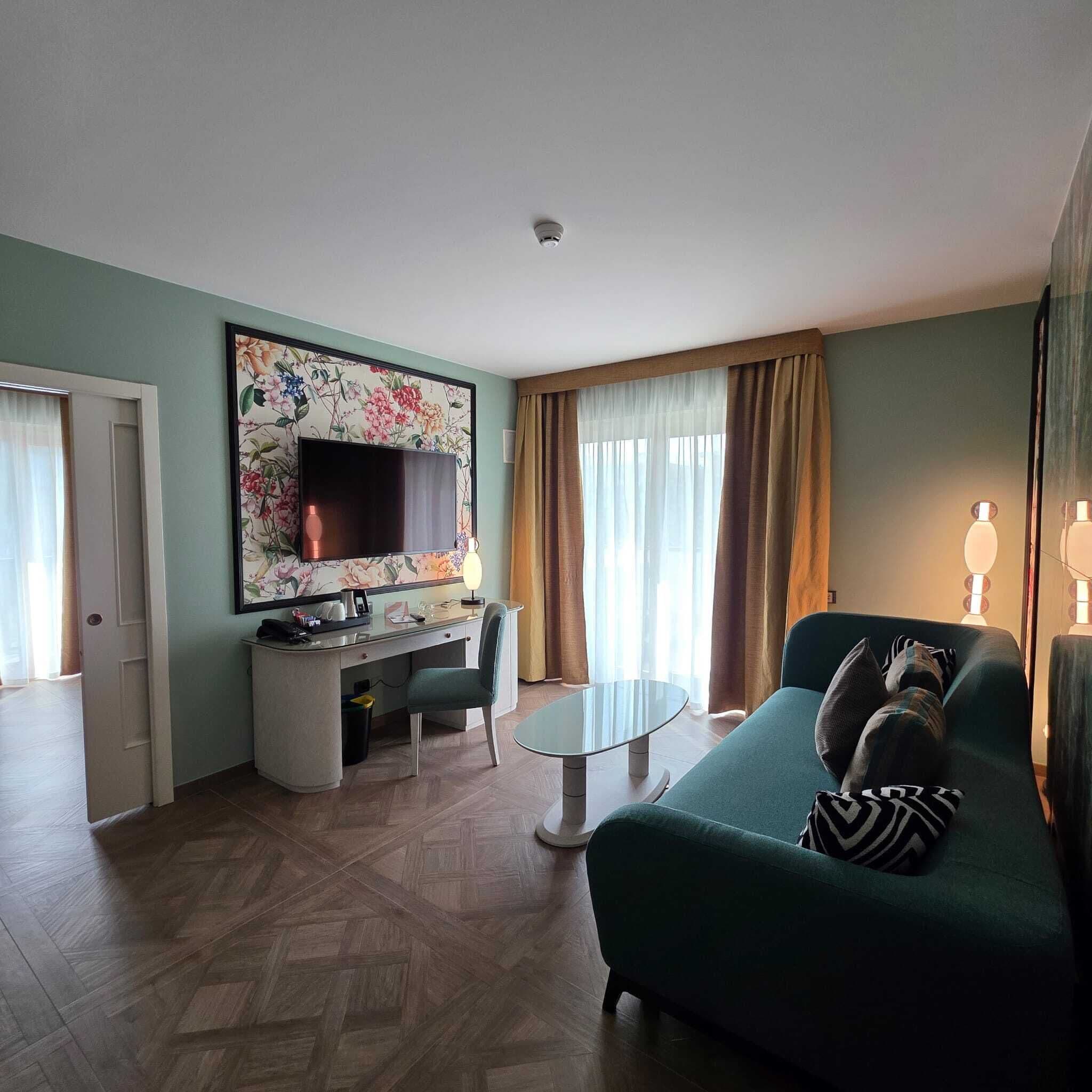 A living room with a sofa, a desk with a TV, and a chair.