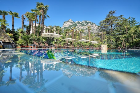 Una piscina al aire libre de temporada, sombrillas