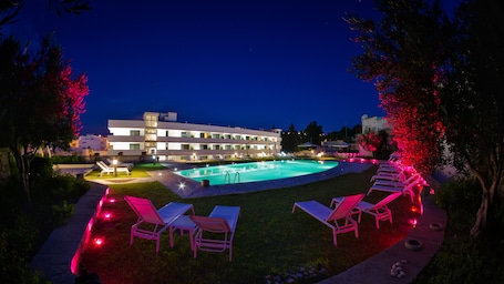 Una piscina al aire libre de temporada, sombrillas