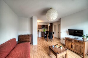 Ein modernes Wohnzimmer mit einer Couch, einem Couchtisch, einem Fernseher und einem Holzkabinett.