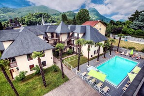 Un hôtel comprenant plusieurs bâtiments, une piscine et situé dans un cadre montagneux.