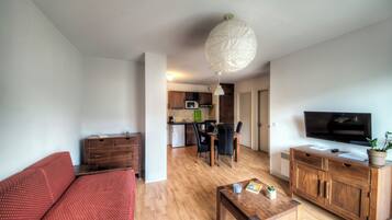 A modern living room with a sofa, a coffee table, a TV, and a wooden cabinet.