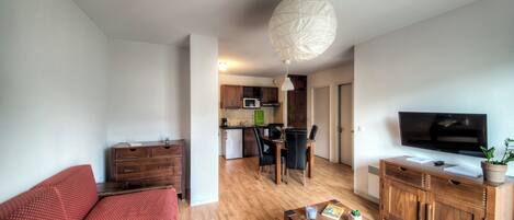 Una sala de estar moderna con un sofá, una mesa de centro, un televisor y un mueble de madera.