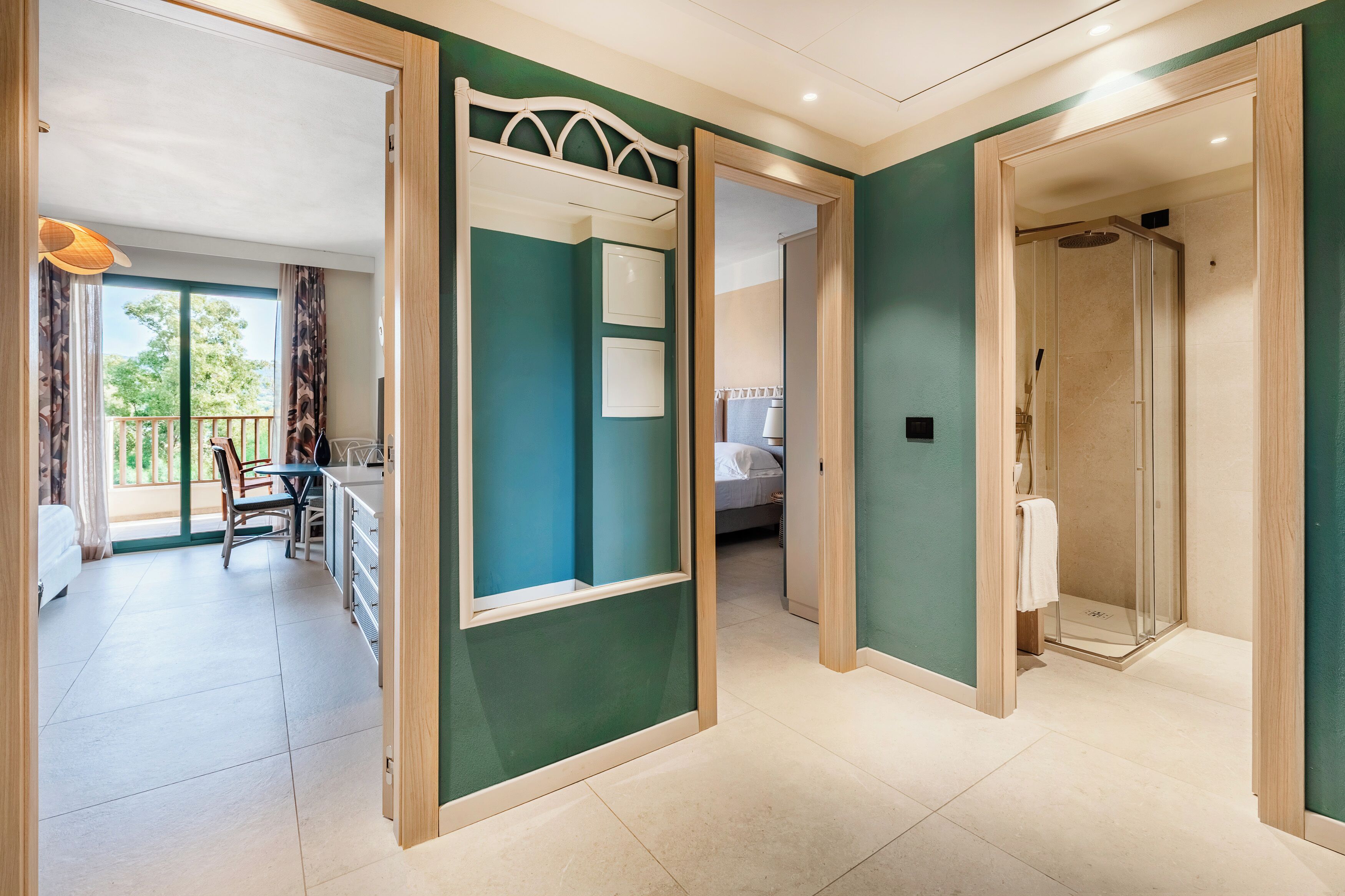 Una habitación de hotel con balcón, zona de comedor y ducha.