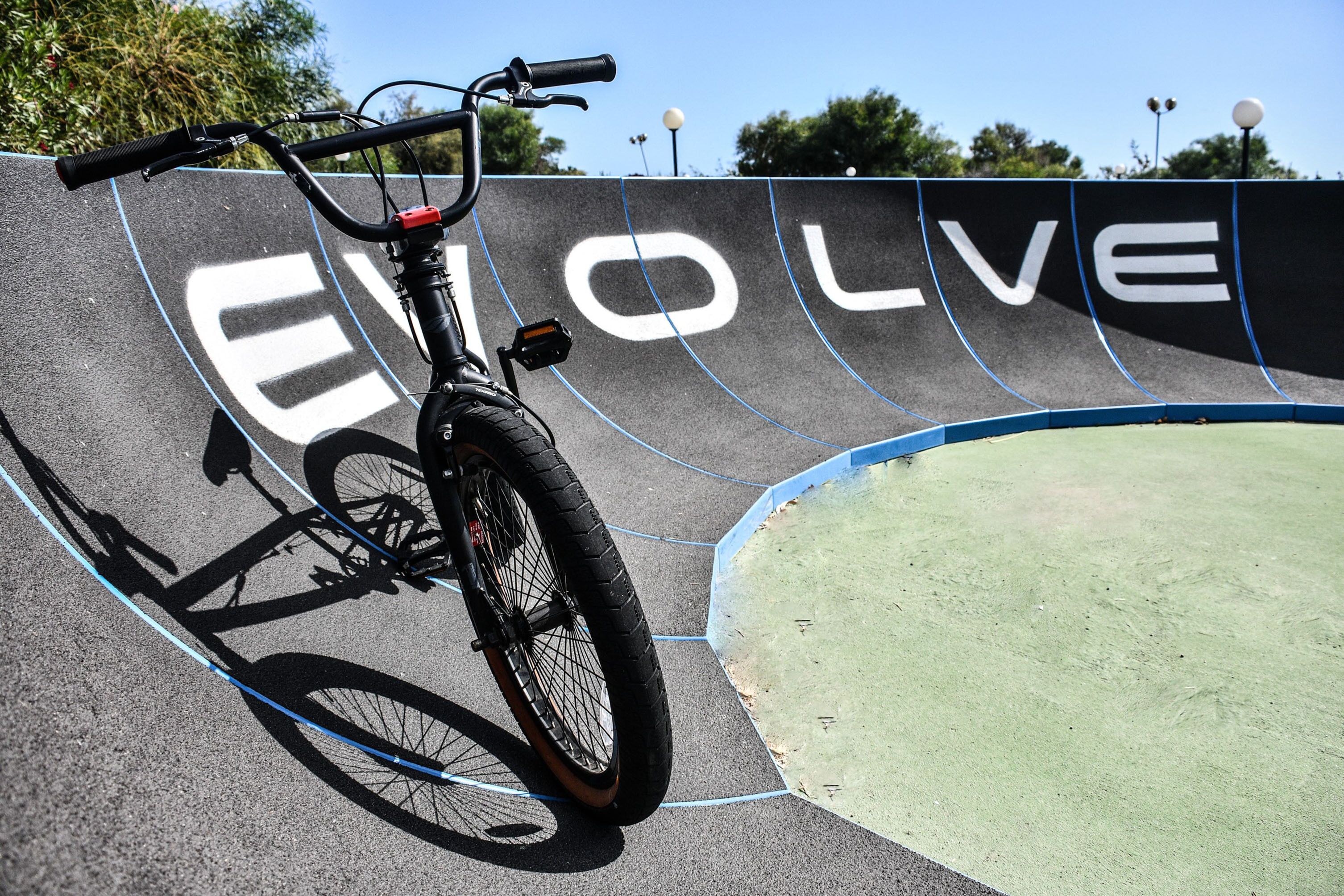 Uma bicicleta encostada na parede com a palavra 'Evolve' pintada.