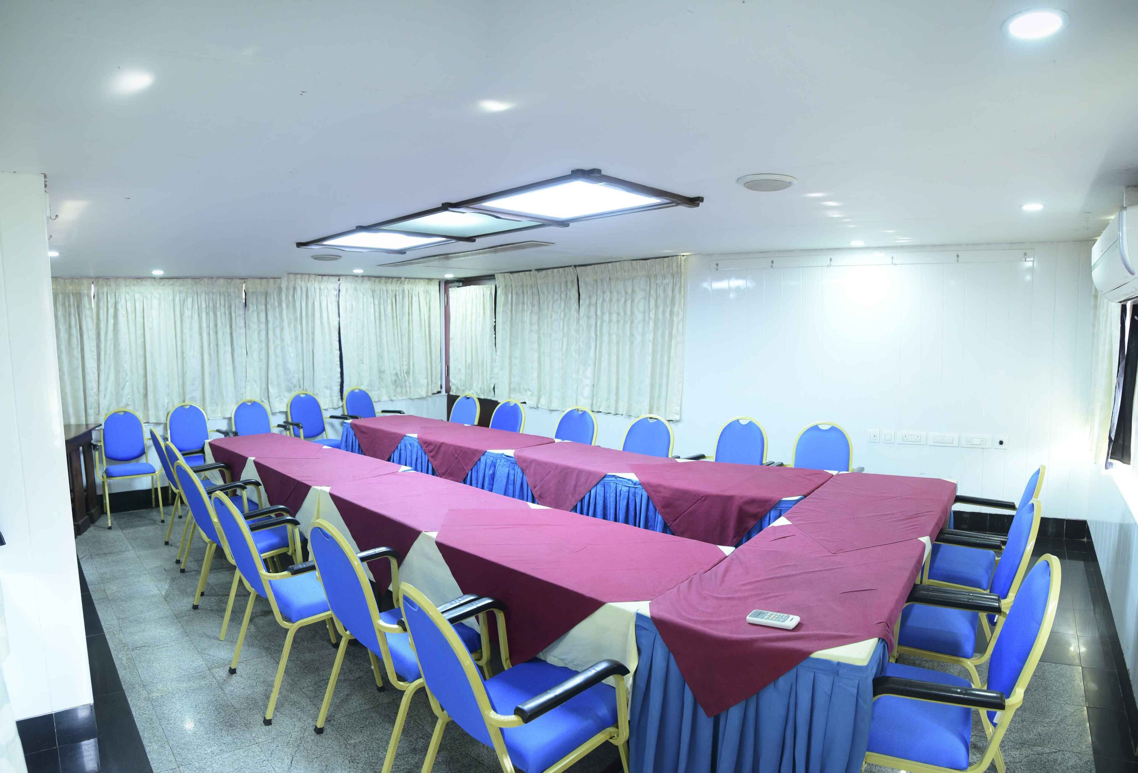 A conference room with a long table, blue chairs, and a whiteboard.