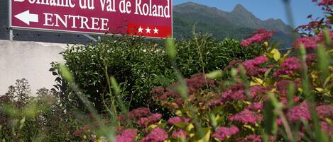 Señal de Domaine du Val de Roland con una flecha señalando a la izquierda.