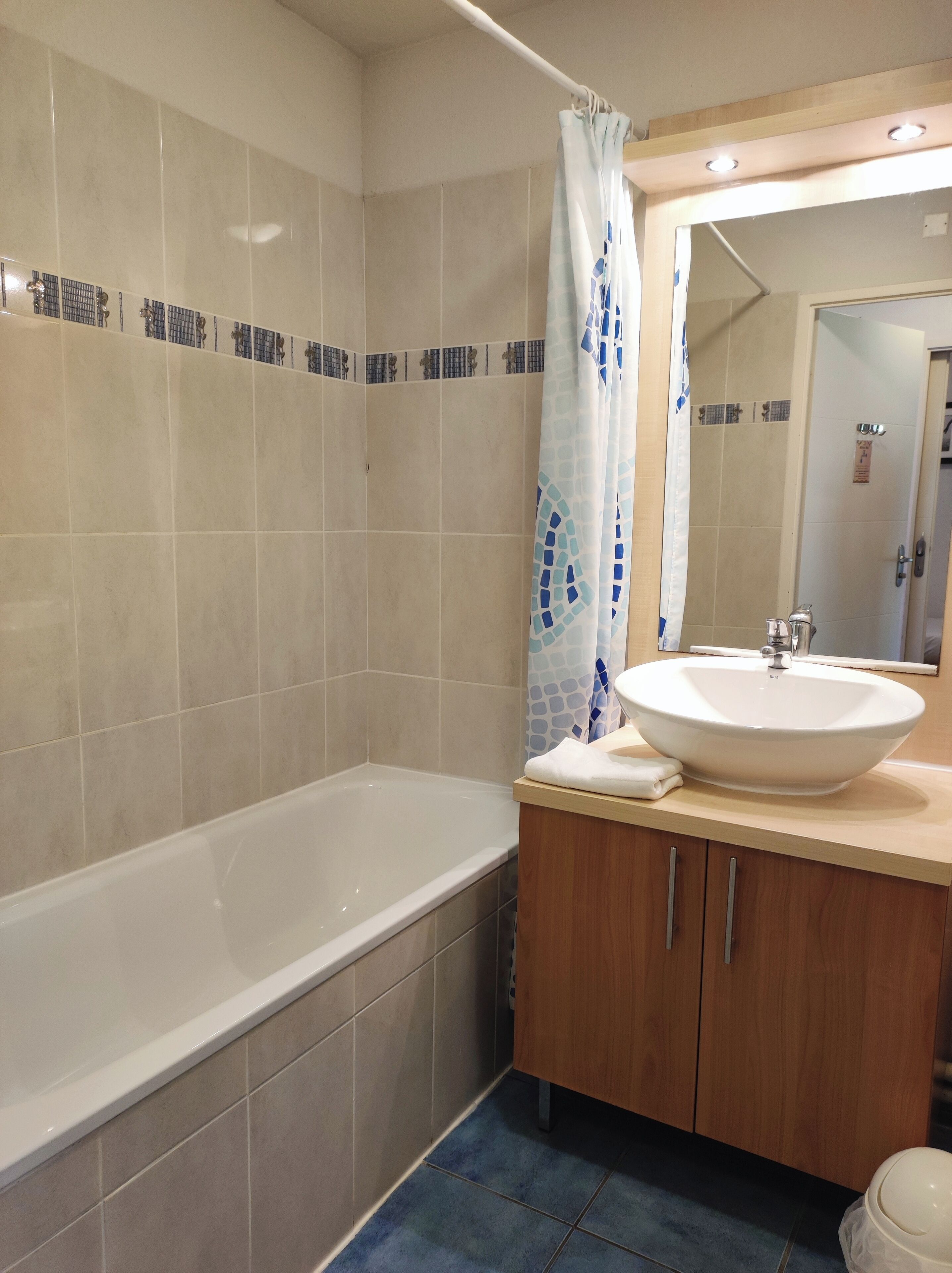 Un baño con bañera, lavamanos y espejo.