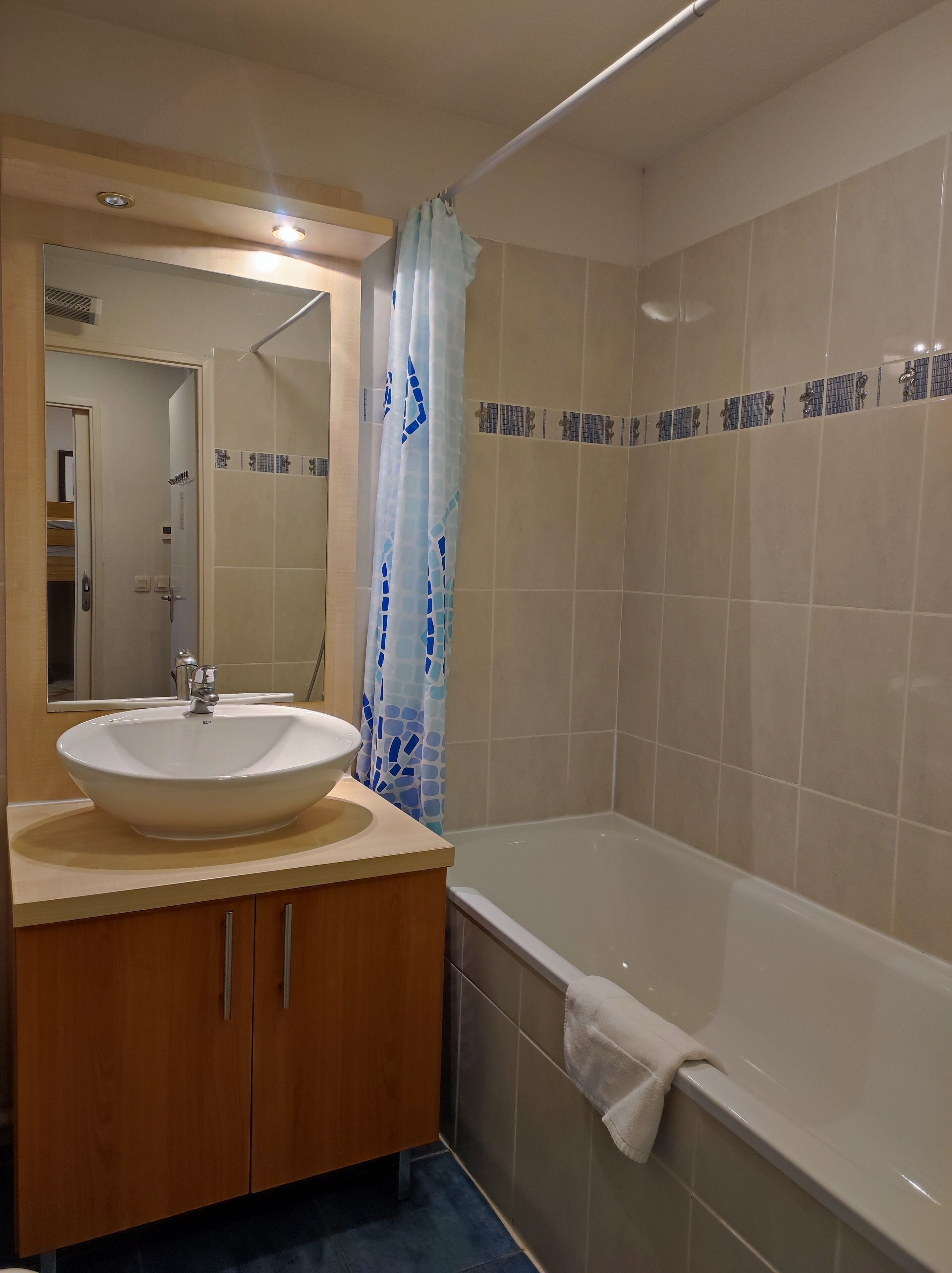 Un baño con lavamanos, espejo y bañera.
