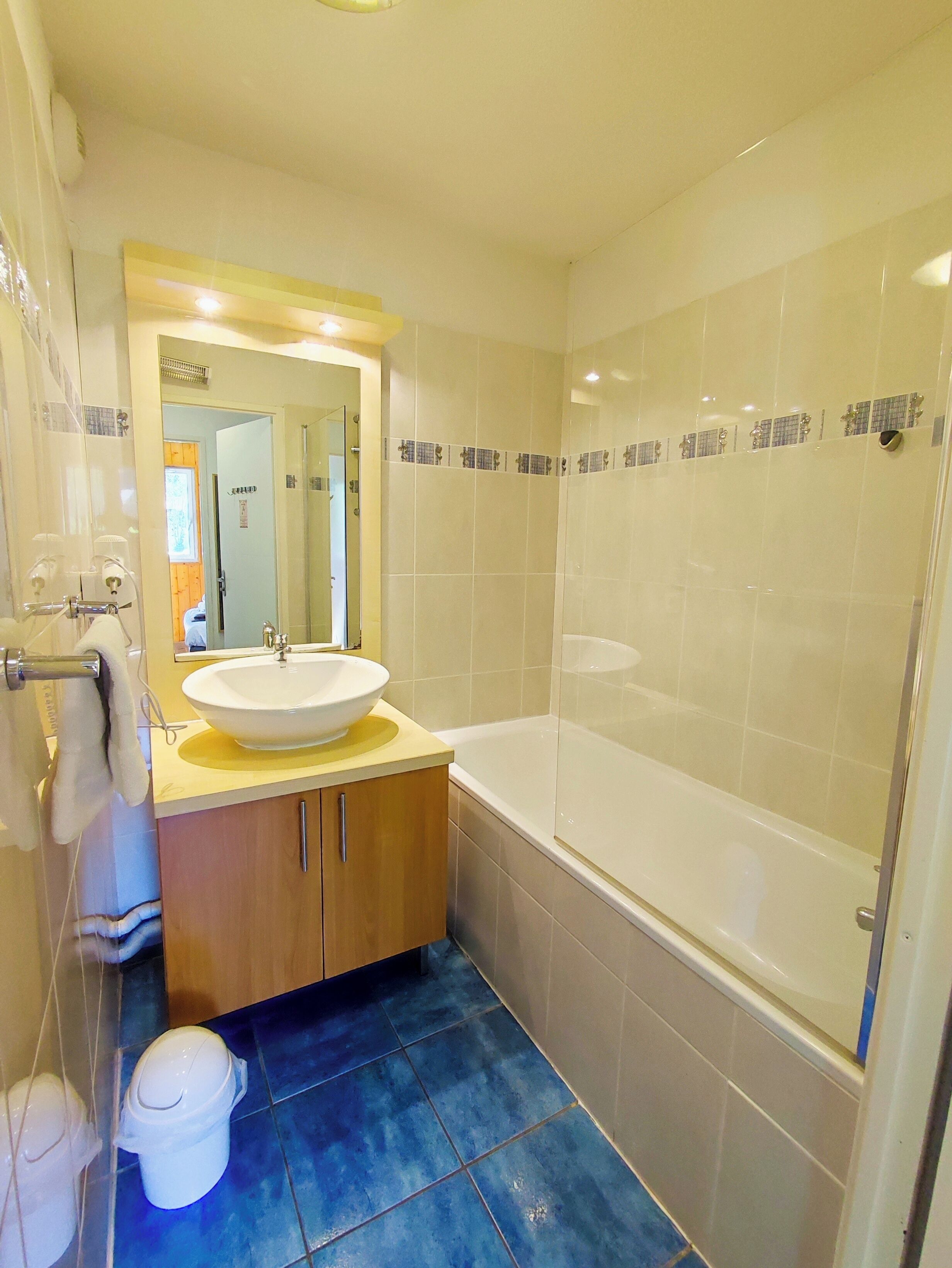 Un baño con lavamanos, espejo y bañera.