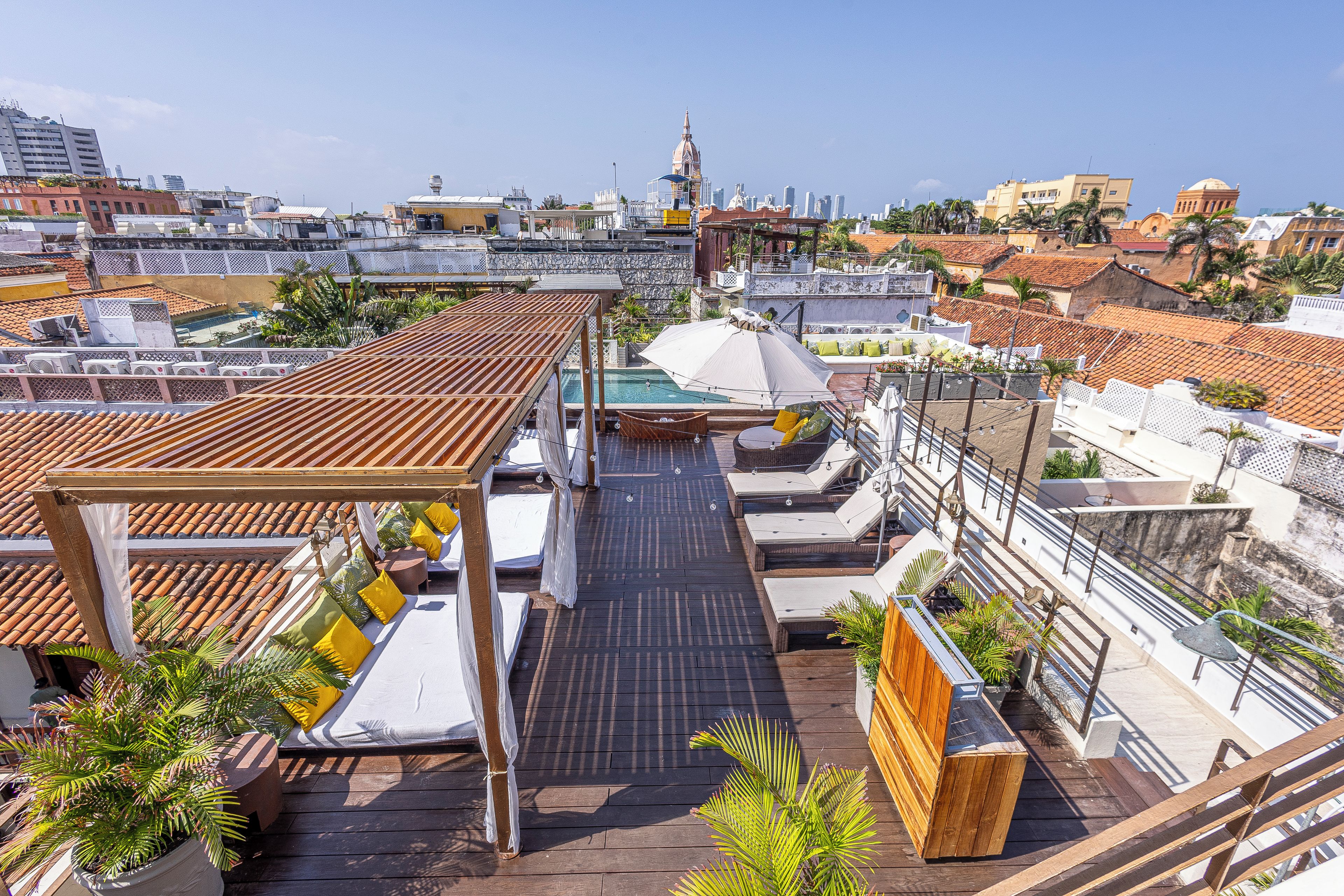 Terraço no terraço com espreguiçadeiras, piscina e vista para o horizonte da cidade.