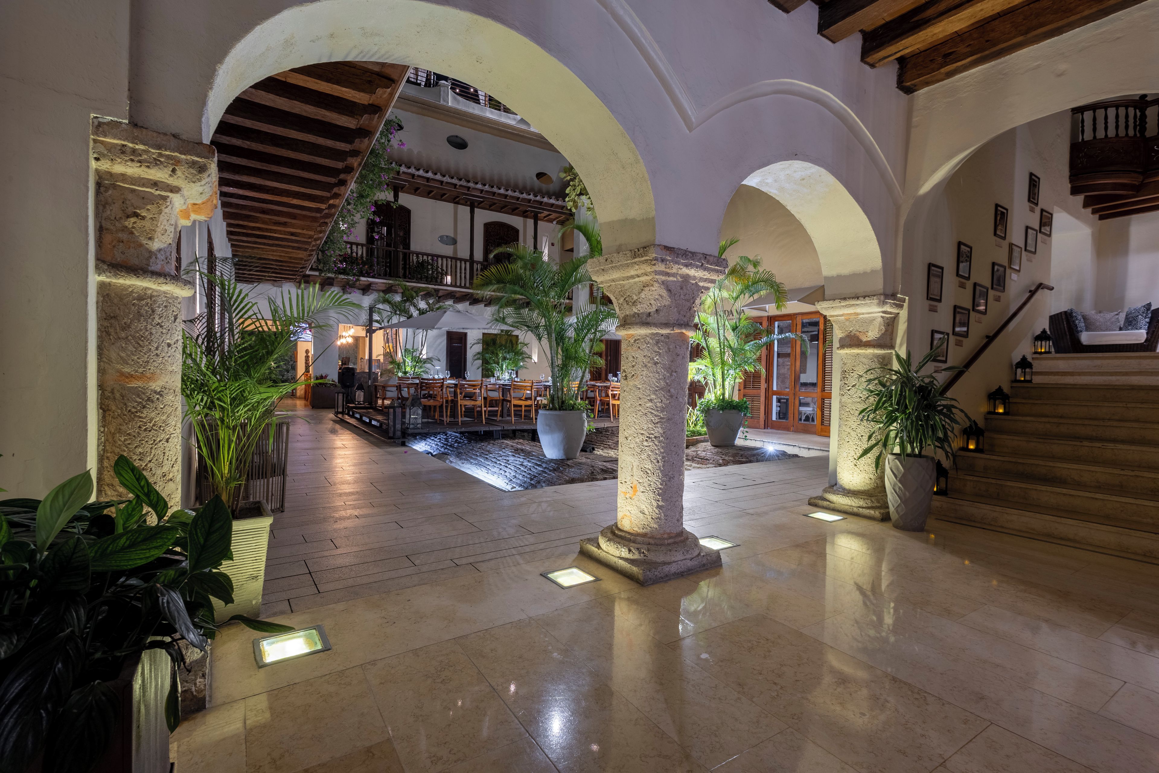 A spacious lobby with a high ceiling, stone columns, and a central fountain.