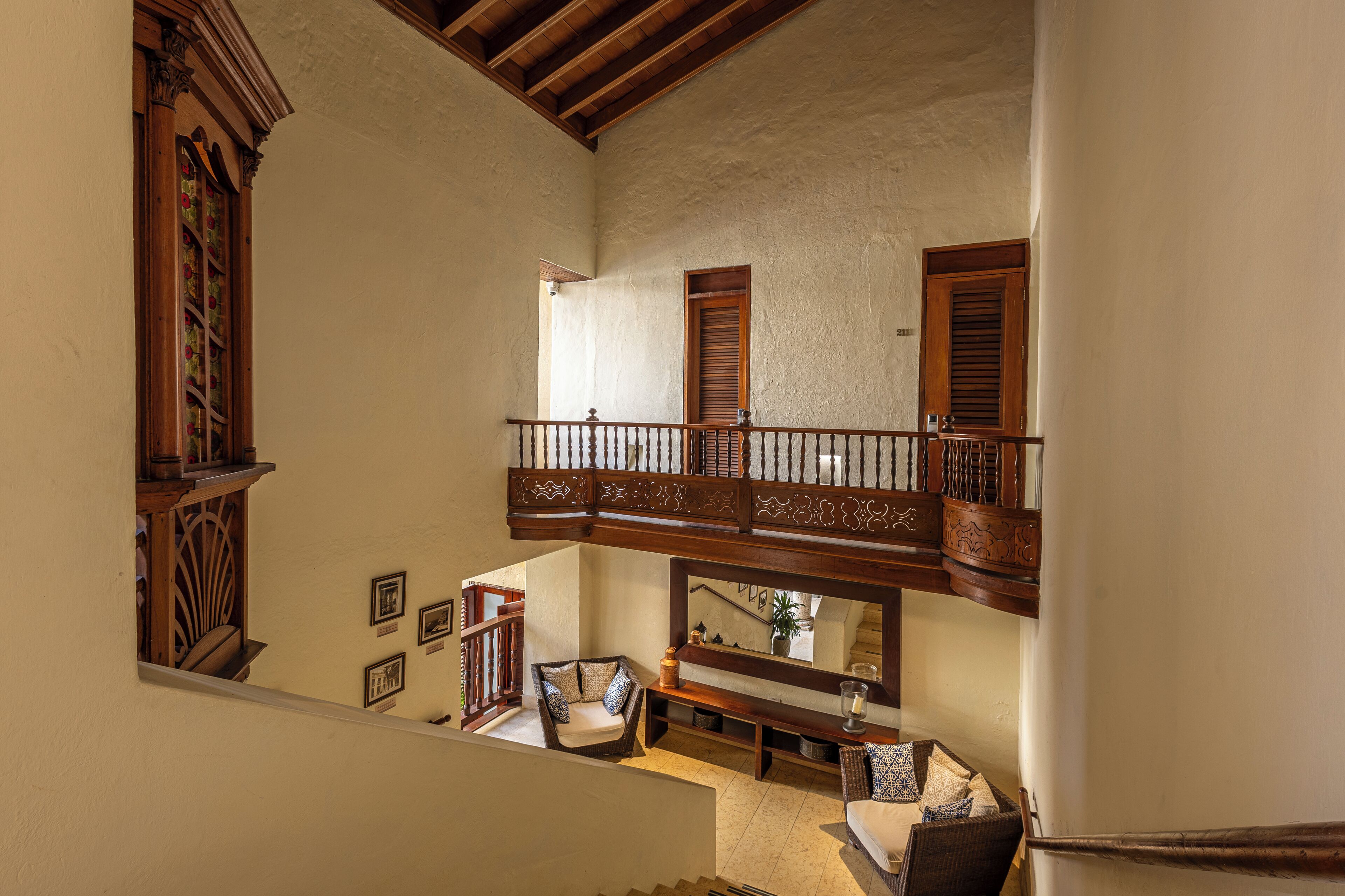 A multi-level interior with a balcony, wooden railings, and a staircase.
