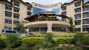 A modern hotel with a central atrium, multiple floors, and a prominent entrance. - Metropole Hotel Kampala (Kampala)