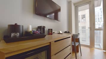 Une cuisine moderne dotée d’un plan de travail en bois, d’une machine à café et d’un téléviseur à écran plat fixé au-dessus.