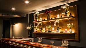 A bar area with a long wooden counter, red placemats, and multiple wine glasses. - Hotel 32 32 (New York)