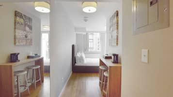 Une chambre d’hôtel équipée d’une kitchenette, d’un lit et d’une salle de bain.