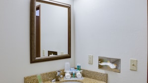 A bathroom with a granite countertop sink, a mirror, and a towel rack. - Holiday Inn Express Hotel & Suites Dubuque by IHG (Dubuque)