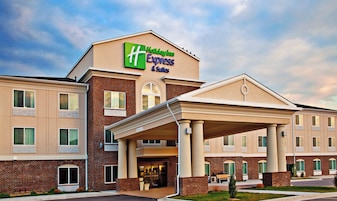 A Holiday Inn Express & Suites building with a covered entrance and multiple windows.